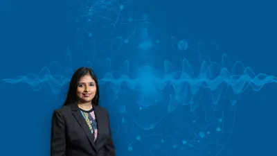 Shohini Ghose, Professorin für Quantenphysik und Computerwissenschaften, vor einem blauen Hintergrund.