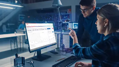 Zwei Mitarbeitende schauen auf einen Bildschirm, der Künstliche Intelligenz visualisiert.