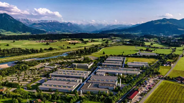 Moderne Fabrikanlage ohne sichtbare Emissionen in einem grünen Tal.