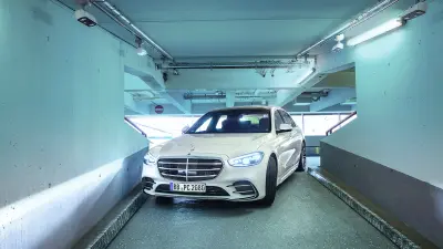 A Mercedes-Benz S-Class autonomously navigates a tight corner in parking garage P6. Bosch cameras can be seen on the ceiling of the park deck.