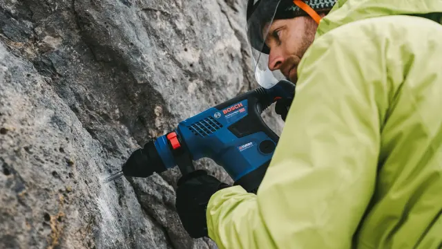 Bernhard Wirtz setzt mit seinem Akku-Werkzeug, dem Bosch Biturbo-Bohrhammer, ein Loch in eine Kalksteinwand.