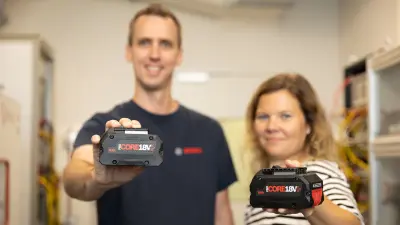 Zwei Bosch Mitarbeitetnde zeigen Bosch CORE18V+ Akkus.