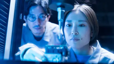 Person in a lab coat holding a pipette under blue lighting; face partially obscured by graphic overlays.
