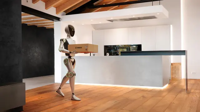 Robot holding a Bosch box in a minimalist kitchen interior.