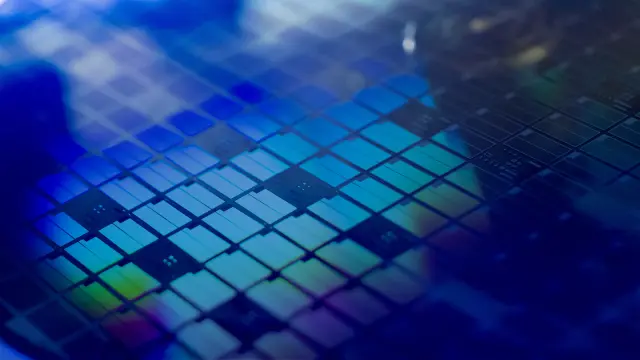 Close-up of a silicon carbide wafer with microchips etched onto it.