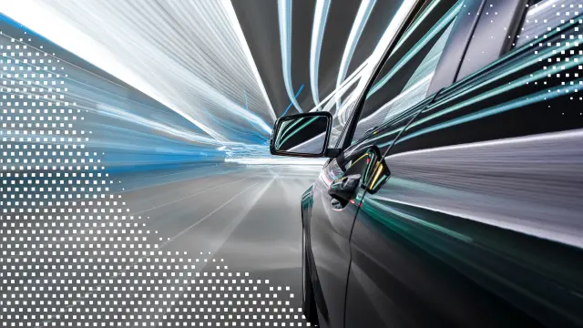 Ein Auto fährt schnell durch einen Tunnel mit dynamischen Lichtstreifen; der Boden ist mit quadratischen Pixelcodes überlagert.