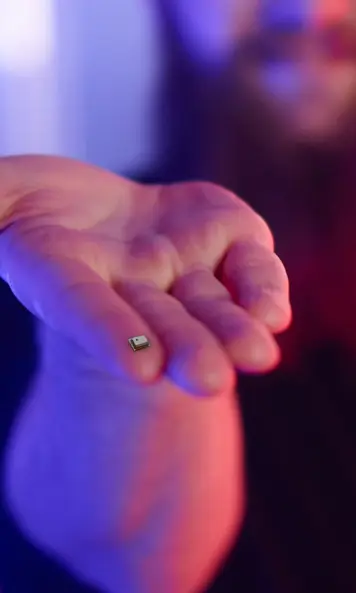 Eine Hand hält einen winzigen Sensor an seiner Fingerspitze
