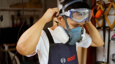 Der Handwerker Brian Tan zieht seine Schutzausrüstung an.