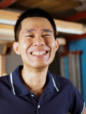 Der Handwerker Brian Tan lächelt in die Kamera.