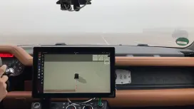 Interior of a car with a dashboard screen showing a 3D vehicle model.