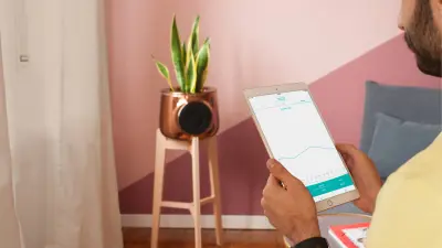 Ein Mann hält einen Tablet-Computer, auf dessen Bildschirm ein Chart zu sehen ist. Im Hintergrund steht Clairy.