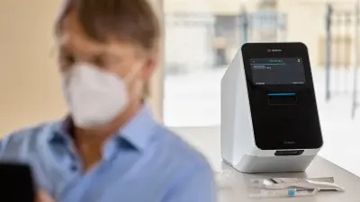 The Vivalytic PCR diagnostic platform is in focus in the background, Clemens Weller is out of focus in the foreground.