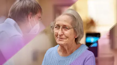 Clemens Weller welcomes his mother Ute Weller. He is wearing a mask. In the background you can see the PCR diagnostic platform Vivalytic, which enables Corona rapid tests.