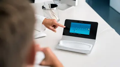 Close-up of hand pointing at medical device display with chart