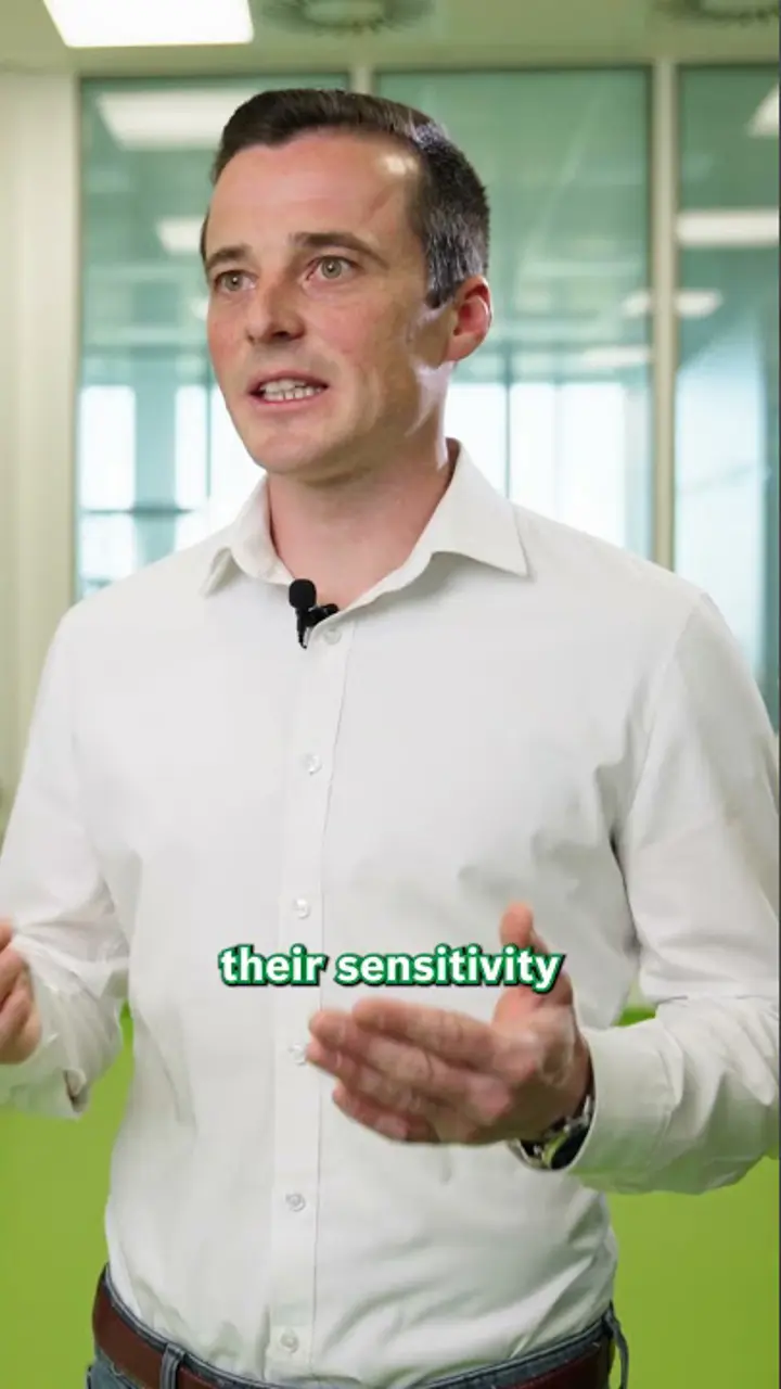 Speaker in glass-walled office; subtitle reads “their sensitivity” 