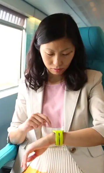 The image shows a woman with a smartwatch in a train.