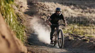 Jed Mildon riding down a hill on an e-bike.