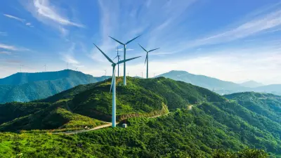 Many wind turbines on a lush green mountain landscape
